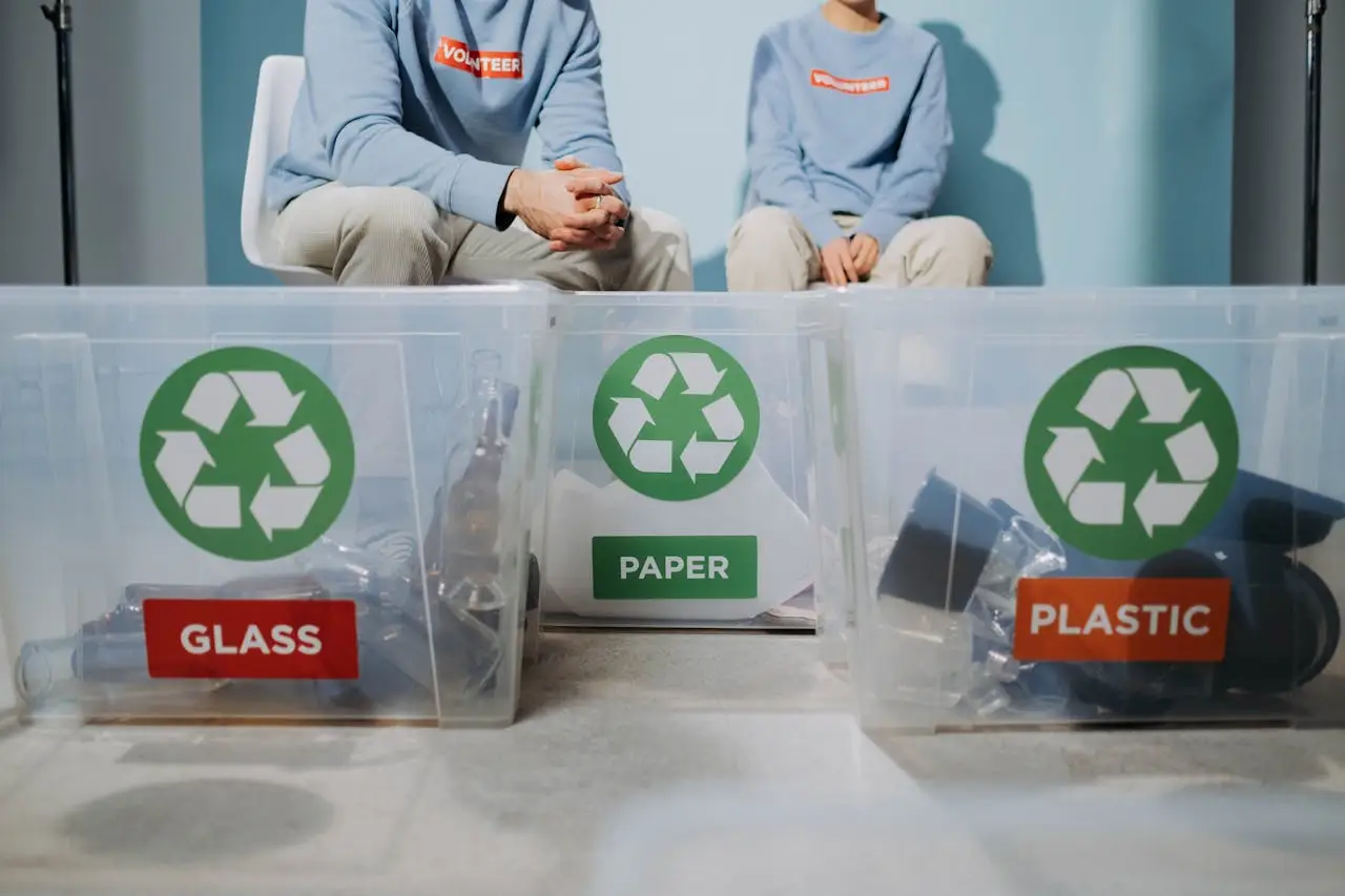 Volunteers organize recyclables into glass, paper, and plastic bins to promote eco-friendly practices.