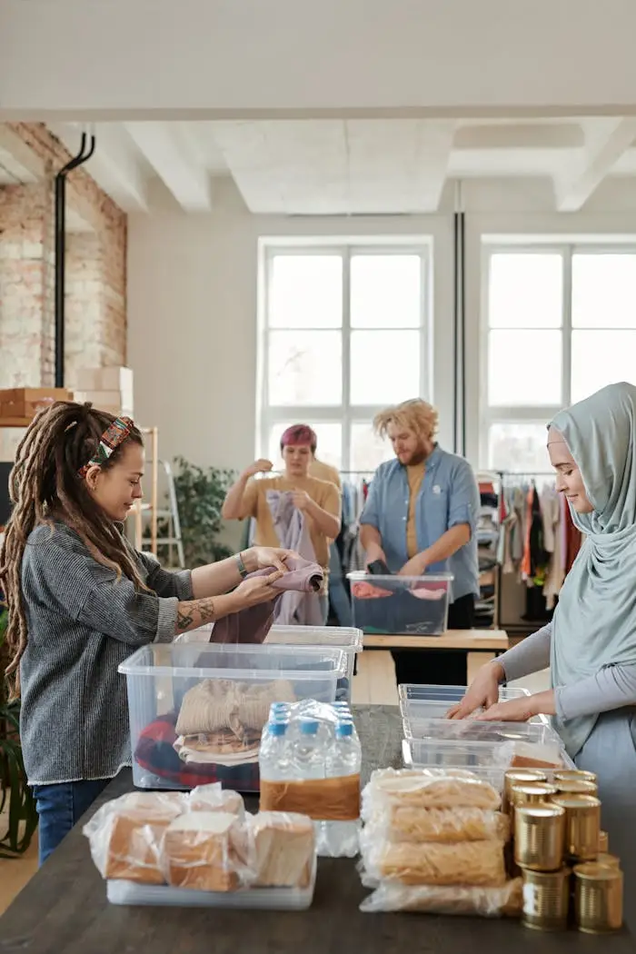 A diverse group of volunteers sorting clothes and food items at an indoor donation center.